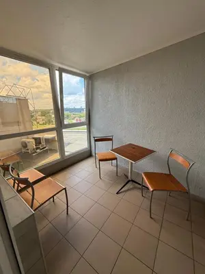 a room with tables and chairs and a large window at Velga in Vilnius