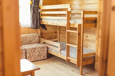 a room with two bunk beds and a chair at Pušynėlis in Miežonys