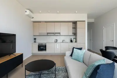 a living room with a couch and a kitchen at Korio Apartments, Druskininkai in Druskininkai