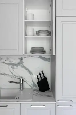a kitchen with white cabinets and a sink and a counter at Korio Apartments, Druskininkai in Druskininkai