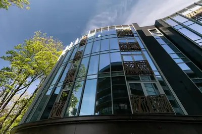 a tall glass building with a lot of windows at Korio Apartments, Druskininkai in Druskininkai