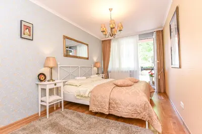 a bedroom with a bed and a table and a mirror at 2 kambarių apartamentai su virtuve, Trakų miesto centre in Trakai