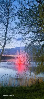 a large body of water with a fire in the distance at 2 kambarių apartamentai su virtuve, Trakų miesto centre in Trakai
