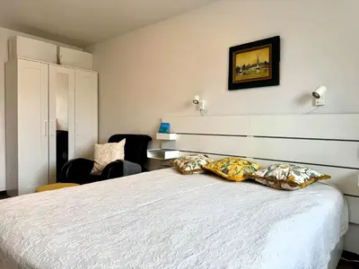 a bedroom with a bed and a chair at Apartment in the City center in Druskininkai