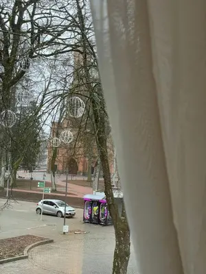 a car parked in a parking lot in front of a building at Taikos Apartmentai 2 in Druskininkai