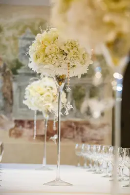a bunch of wine glasses with flowers on a table at Šiauliu Krasto Medžiotojų Užeiga in Šiauliai