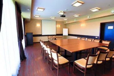 a conference room with a large wooden table and chairs at Šiauliu Krasto Medžiotojų Užeiga in Šiauliai