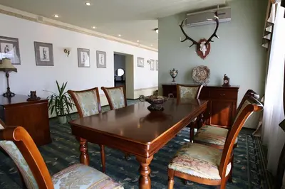 a dining room with a wooden table and chairs at Šiauliu Krasto Medžiotojų Užeiga in Šiauliai