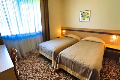 a hotel room with two beds and a window at Šiauliu Krasto Medžiotojų Užeiga in Šiauliai