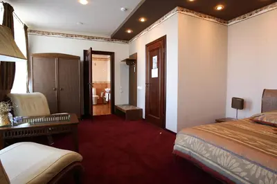 a hotel room with a bed and a desk and a chair at Šiauliu Krasto Medžiotojų Užeiga in Šiauliai