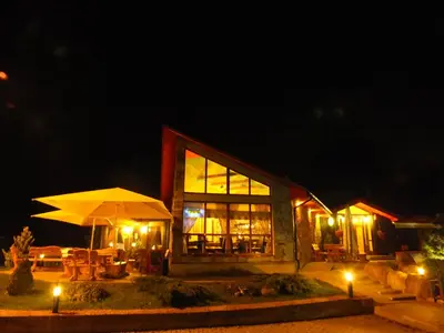 a building with an umbrella in front of it at night at Hotel Green Smiltynė in Panevėžys