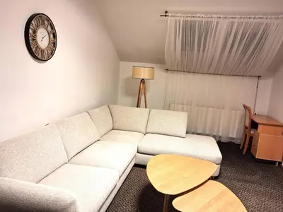 a living room with a white couch and a table at Turnė in Šiauliai