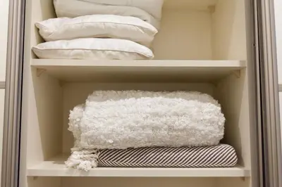 a closet filled with white pillows and towels at M.K. Apartments in Vilnius