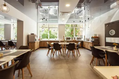 a restaurant with tables and chairs and a counter at Old Town Trio Hostel Rooms in Vilnius