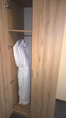 a closet with a white robe hanging in it at Old Town Trio Hostel Rooms in Vilnius