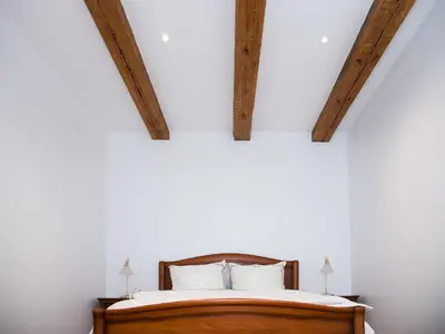 a bedroom with a bed with two beams at Skapas Street Vilnius in Vilnius