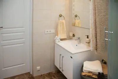 a white bathroom with a sink and a mirror at Skapas Street Vilnius in Vilnius