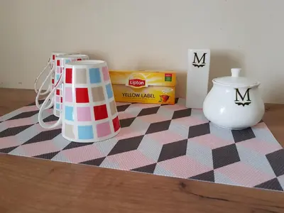 a table with two vases on a checkered rug at K-Town - Apartment near the Lake in Kaunas