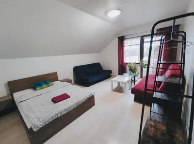 a bedroom with a bed and a blue couch at K-Town - Apartment near the Lake in Kaunas