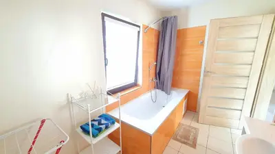 a bathroom with a tub and a window and a sink at K-Town - Apartment near the Lake in Kaunas
