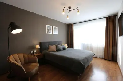 a bedroom with a bed and a chair and a window at Modern 2 Rooms Apartment in Kaunas
