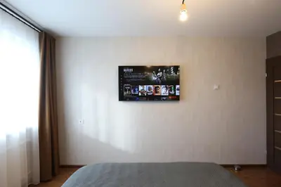 a bedroom with a flat screen tv on the wall at Modern 2 Rooms Apartment in Kaunas