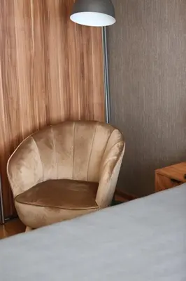 a leather chair in a room with a bed at Modern 2 Rooms Apartment in Kaunas