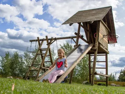 a little girl sitting on a wooden slide at Homestead Sartakampis in Gipenai