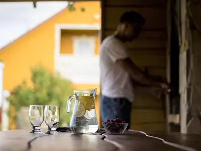 a man standing on a table with two wine glasses at Homestead Sartakampis in Gipenai