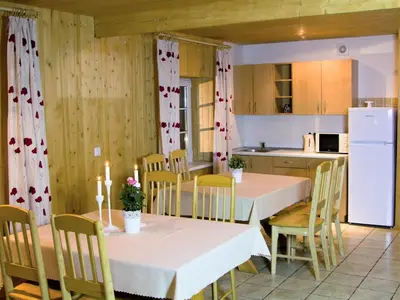 a kitchen and dining room with two tables and chairs at Homestead Sartakampis in Gipenai