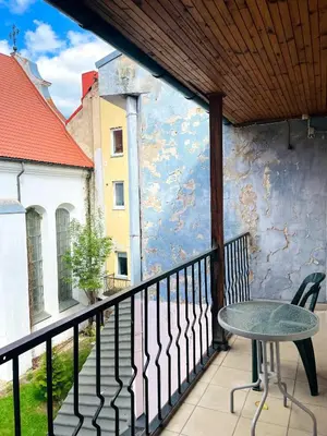 a table and chair on a balcony with a building at Mikalo House in Vilnius