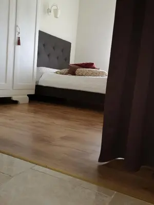 a bedroom with a bed and a wooden floor at Jaukus butas Šiaulių miesto centre in Šiauliai