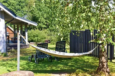 a hammock in a yard next to a tree at Ažuluokesos sodyba in Molėtai