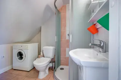 a bathroom with a toilet and a sink and a washing machine at Vidos Apartamentai in Vilnius