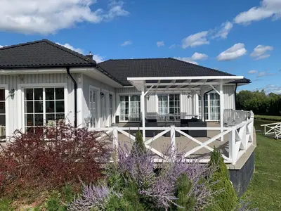 a white house with a porch and a fence at Vila Bianca in Inturkė
