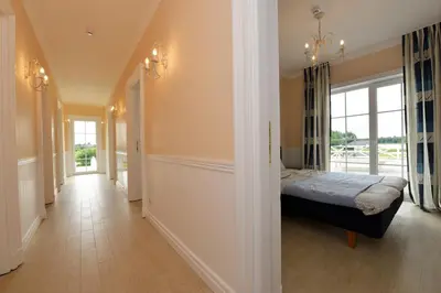 a bedroom with a bed and a hallway with a window at Vila Bianca in Inturkė