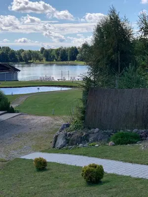 a walkway next to a lake with a bridge at Vila Bianca in Inturkė