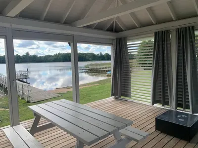 a porch with a picnic table and a view of a lake at Vila Bianca in Inturkė