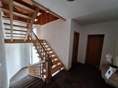 a wooden staircase in a room with a door at Home B&B in Kaunas