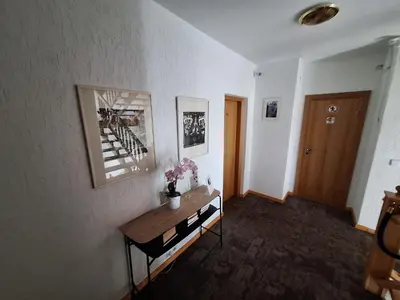 a living room with a table and a hallway at Home B&B in Kaunas