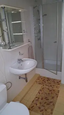 a bathroom with a sink and a shower and a toilet at Home B&B in Kaunas