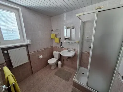a bathroom with a shower and a toilet and a sink at Home B&B in Kaunas