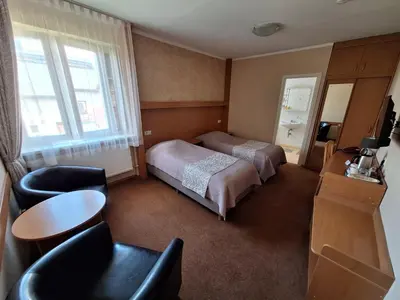 a hotel room with a bed and a table and chairs at Home B&B in Kaunas