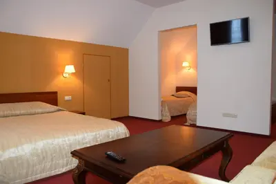 a hotel room with two beds and a coffee table at Girele in Šiauliai