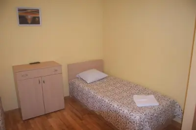 a small bedroom with a bed and a cabinet at Girele in Šiauliai