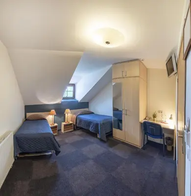 a small room with two beds and a sink at Hotel - Bar Grafaite in Šiauliai