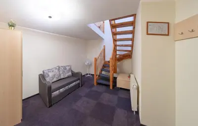 a living room with a chair and a staircase at Hotel - Bar Grafaite in Šiauliai