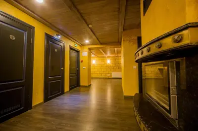 a hallway with a fireplace in a room with yellow walls at Hotel - Bar Grafaite in Šiauliai