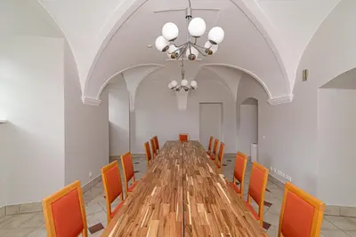 a long table in a room with orange chairs at Domus Maria in Vilnius