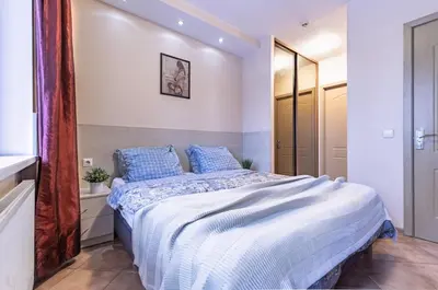 a bedroom with a large bed with blue pillows at Mara in Vilnius